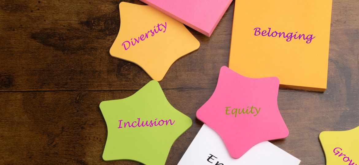 DEI concept.  Diversity, Equity, Inclusion, and Belonging.  Inspire, Engage, and Grow.  Text on colorful note pads on desk.